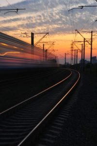 rail road under gray and orange cloudy sky during sunset